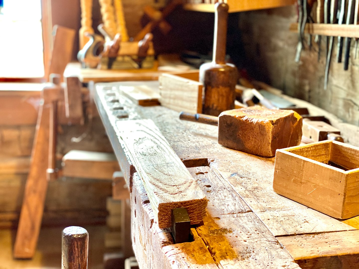 Workbench with timber secured by a vise and mallet.