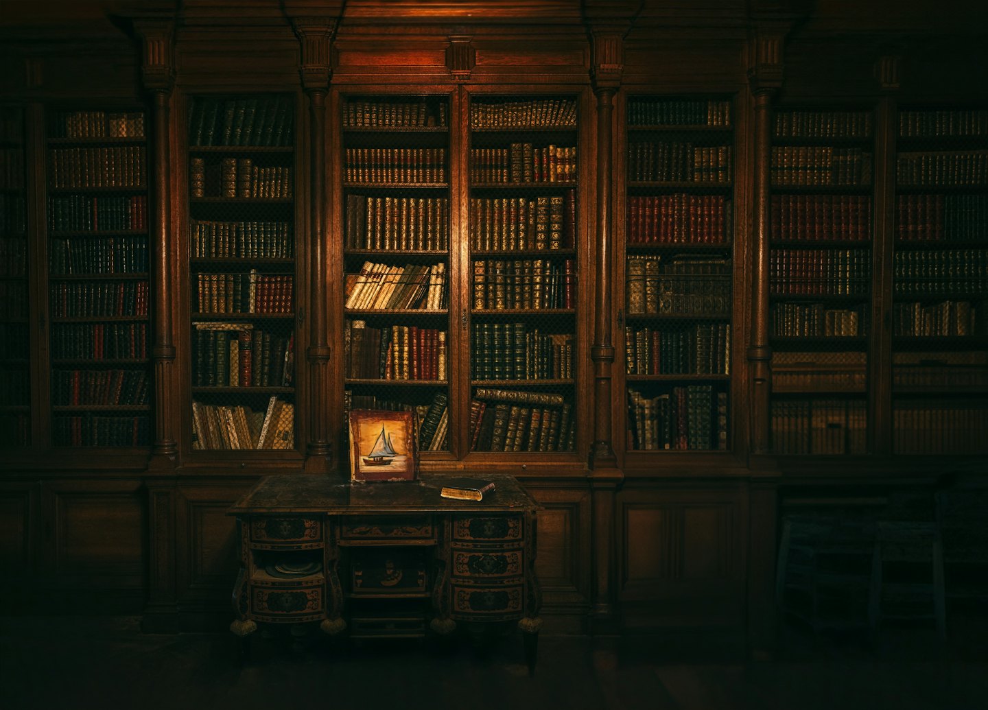 Antique library desk with books and sailboat art.